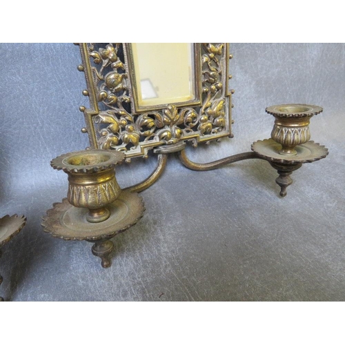 868 - A PAIR OF EARLY 20TH CENTURY BRASS PIERCED MIRRORED WALL SCONCES, each with a pair of candle holders... 