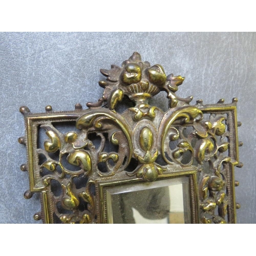 868 - A PAIR OF EARLY 20TH CENTURY BRASS PIERCED MIRRORED WALL SCONCES, each with a pair of candle holders... 