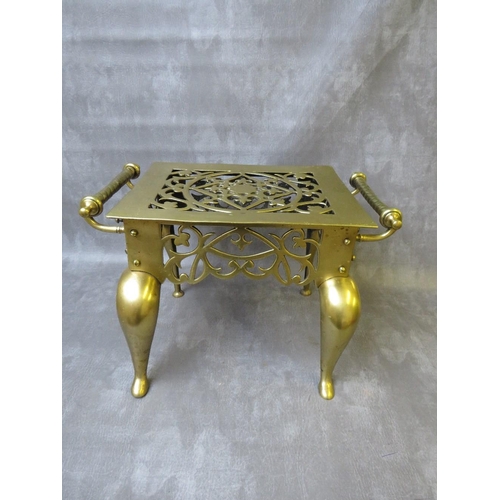 865 - A HEAVY BRASS VINTAGE FOOTMAN, with twin handles and raised on shaped supports, H 30 cm, W 46 cm