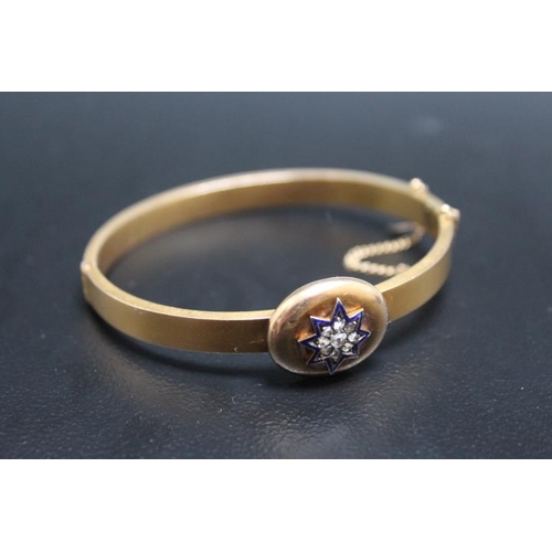 643 - A 15CT DIAMOND AND ENAMEL BANGLE, having a central diamond surrounded by 8 diamonds and these in tur... 