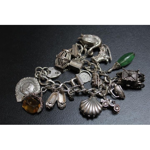 686 - A SUBSTANTIAL SILVER CHARM BRACELET ADORNED WITH MANY LARGE CHARMS, approx weight 138g