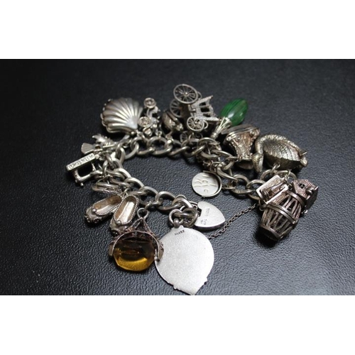 686 - A SUBSTANTIAL SILVER CHARM BRACELET ADORNED WITH MANY LARGE CHARMS, approx weight 138g