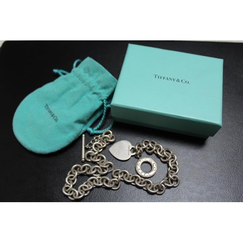 687 - A SILVER TIFFANY & CO NECKLACE CHAIN WITH HEART AND CIRCULAR PENDANTS AND T BAR, complete with a box... 