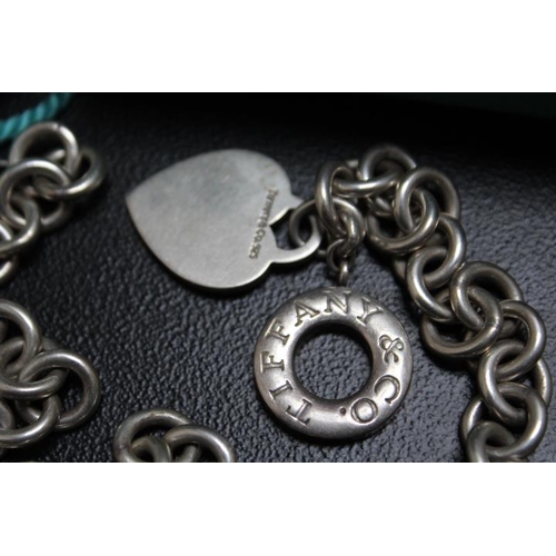 687 - A SILVER TIFFANY & CO NECKLACE CHAIN WITH HEART AND CIRCULAR PENDANTS AND T BAR, complete with a box... 