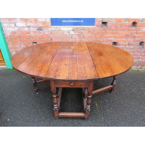 1171 - AN EARLY 19TH CENTURY OAK DROPLEAF GATELEG TABLE, having two frieze drawers, raised on turned suppor... 