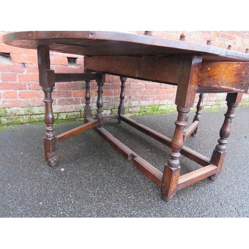 1171 - AN EARLY 19TH CENTURY OAK DROPLEAF GATELEG TABLE, having two frieze drawers, raised on turned suppor... 