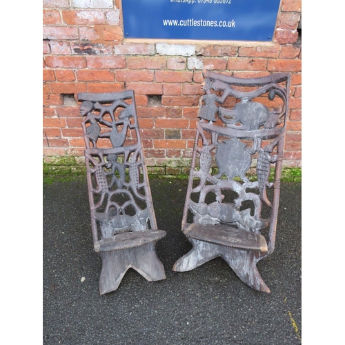 1044 - TWO HEAVILY CARVED AFRICAN TRIBAL CHAIRS