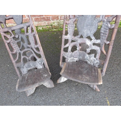 1044 - TWO HEAVILY CARVED AFRICAN TRIBAL CHAIRS