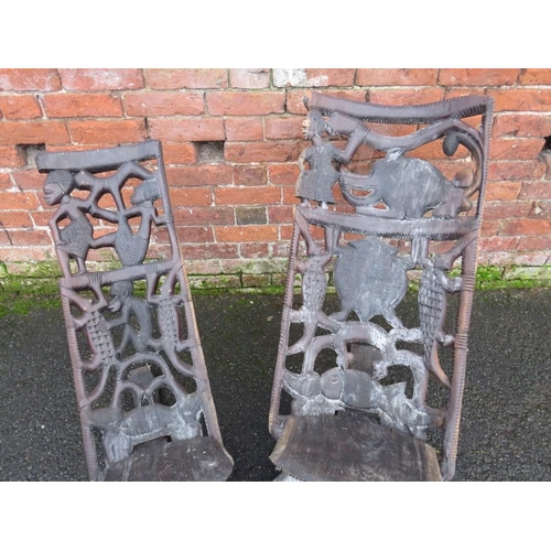 1044 - TWO HEAVILY CARVED AFRICAN TRIBAL CHAIRS