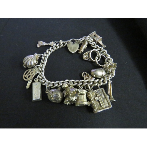 607 - A CHARM BRACELET WITH HALLMARKED SILVER PADLOCK, with 15 attached charms, some hallmarked