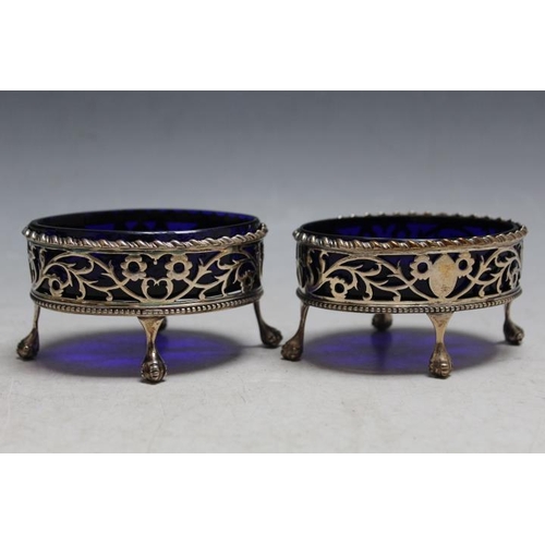 838 - A PAIR OF GEORGIAN HALLMARKED PIERECED SILVER SALT DISHES - LONDON 1773, with blue glass liners, mak... 