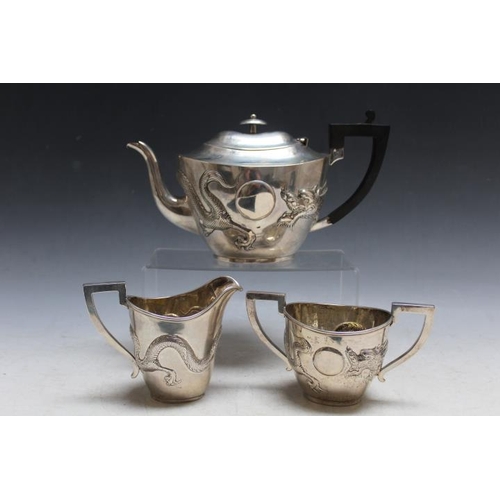 802 - A CHINESE EXPORT SILVER THREE PIECE TEA SERVICE, boldly embossed with a three toed dragon, character... 