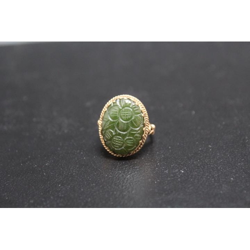 705 - A HALLMARKED 9 CARAT GOLD CARVED OVAL JADE RING, carved with floral design, approx weight 5.4g, ring... 