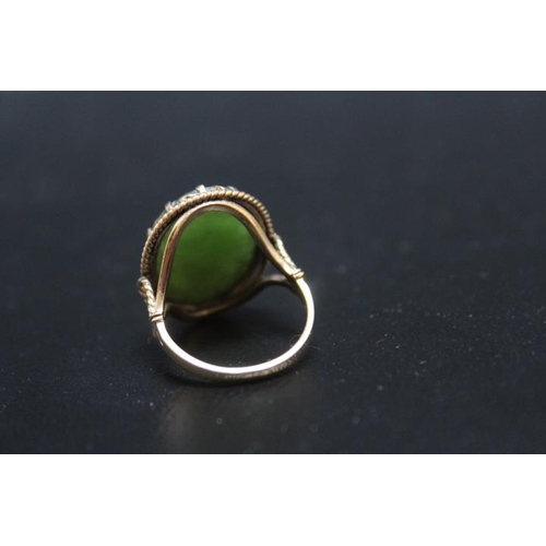 705 - A HALLMARKED 9 CARAT GOLD CARVED OVAL JADE RING, carved with floral design, approx weight 5.4g, ring... 