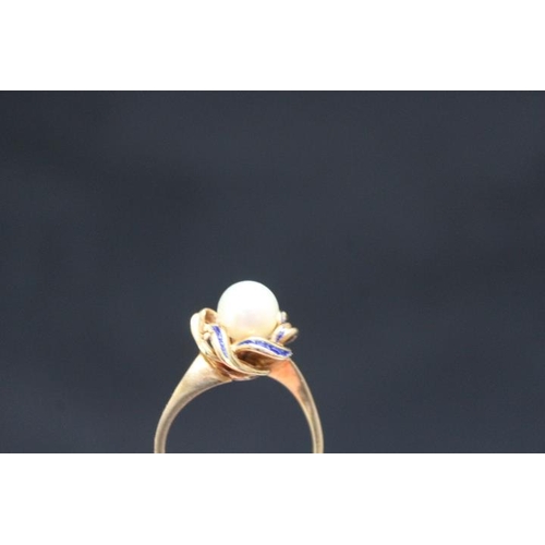 697 - A PEARL RING, set in yellow metal stamped k15 on a 'swirl' bed with blue enamelling, A/F approx weig... 