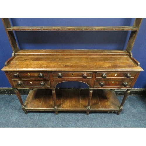 1154 - A 19TH CENTURY OAK DRESSER, with an arrangement of five drawers over an arched apron, raised on turn... 