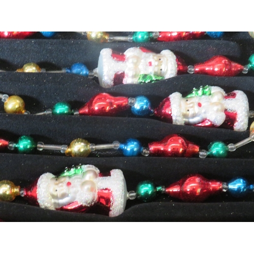 550 - A BOXED SET OF TWO THOMAS PACCONI GLASS BLOWN CHRISTMAS TREE GARLANDS, with inset Santa figures, tog... 