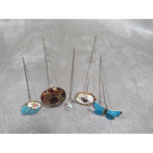 586 - FOUR ENAMEL EMBELLISED HATPINS, to include a hallmarked sliver Charles Horner example, together with... 