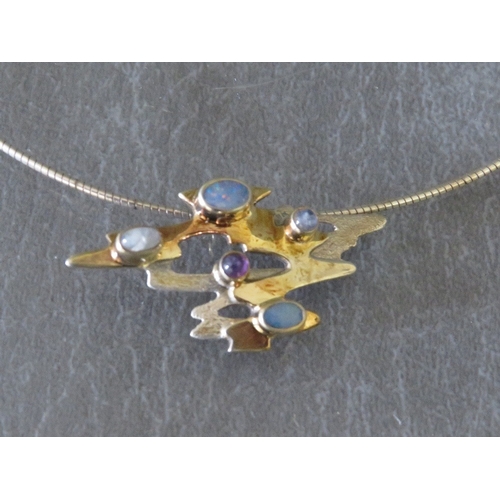 625 - PAULA BOLTON - AN UNUSUAL GEMSET PENDANT NECKLACE, the freeform pendant set with a selection of poli... 