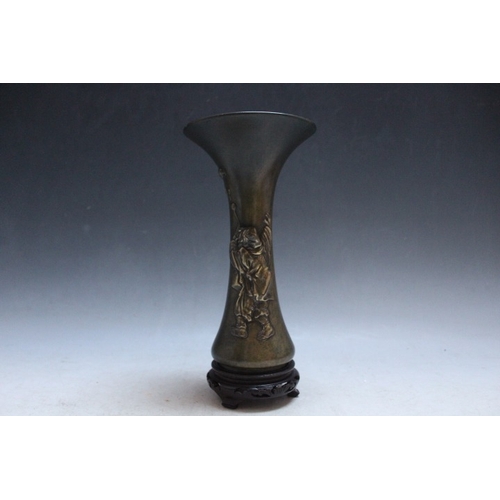 1034 - AN ORIENTAL BRONZE FLARED VASE, decorated with a figure blowing bubbles, character marks to the base... 