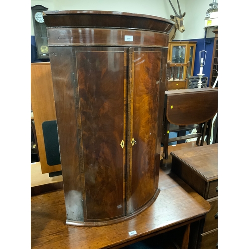 805 - A Georgian mahogany bow fronted hanging corner cupboard