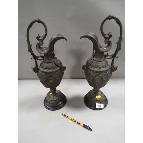 329 - A pair of ornate cast metal ewers