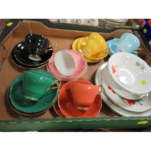 133 - Three trays of tea and dinnerware to include Harlequin cups and saucers, Poole etc