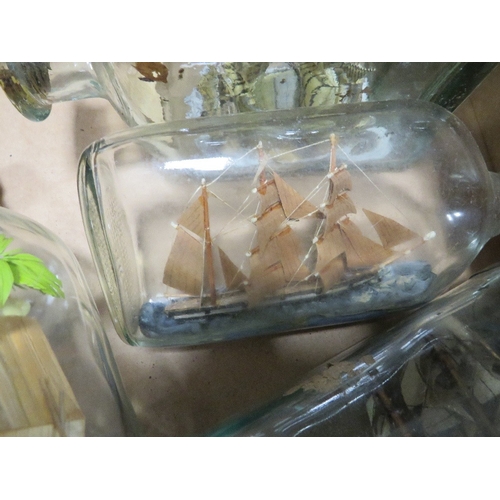 196 - Two trays of model ships in bottles and display cases together with a tray of porcelain bear money b... 