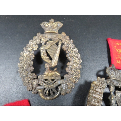 433 - A bag of military badges, to include 2 Royal Irish Rifles helmet plates