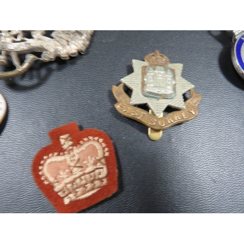 433 - A bag of military badges, to include 2 Royal Irish Rifles helmet plates