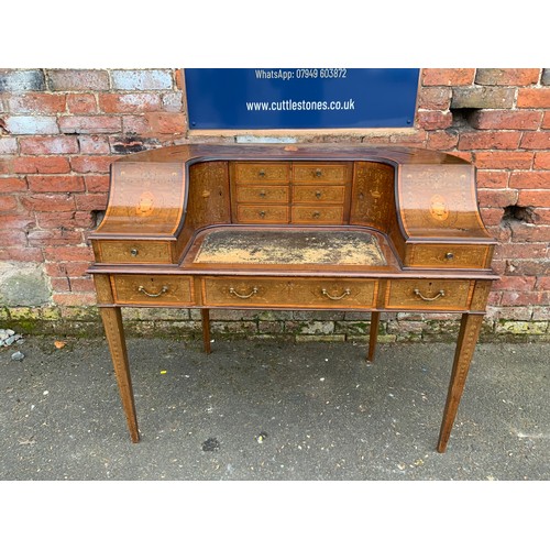 AN EDWARDIAN MAHOGANY AND INLAID 'CARLTON HOUSE' WRITING DESK, having three frieze drawers with inlaid decoration, raised on inlaid tapering supports, the writing surface below six small drawers, flanked by curved inlaid doors with letter slots to the tops, the sides with downward sloping concave panels inlaid with urns over a drawer, H 99 cm, W 122 cm, D 62 cm