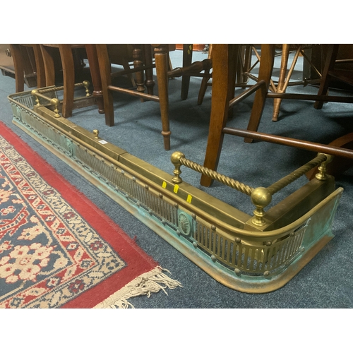 An antique brass pierced fire fender L 158 cm, together with another extending brass fender. (2)
