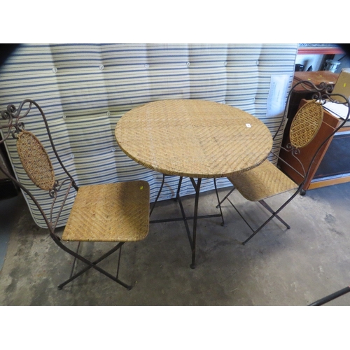 644 - A wrought iron and wicker folding patio garden set comprising a table and two chairs
