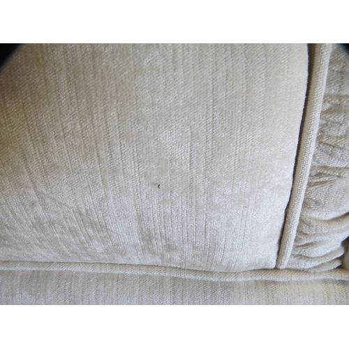 647 - A cream wing backed style 10 cushion sprung edged three piece suite with piped edges and reversible ... 