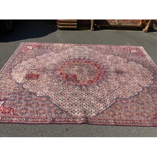703 - A large Eastern woollen rug - mainly red and black, 333 x 245 cm A/F