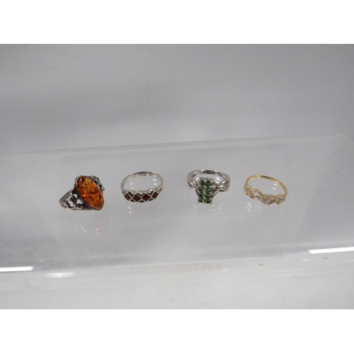 328 - Four dress rings to include a silver amber style example