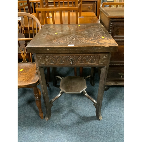 An antique carved oak handkerchief card table
