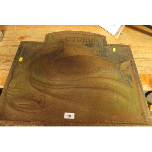 A cast iron vintage fireplace back plate with an image of a swan