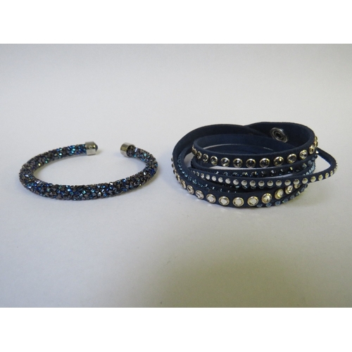 TWO SWAROVSKI DARK BLUE BRACELETS, together with a pair of large single stone Swarovski earrings, all three with swan logo (3)