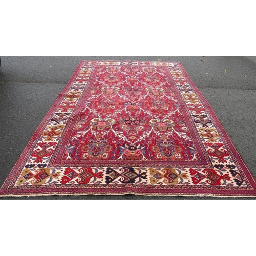 A large Eastern rug in red, blue green and cream, approx 334 x 226 cm