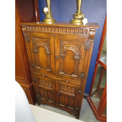 707 - A carved oak priory style drinks cabinet