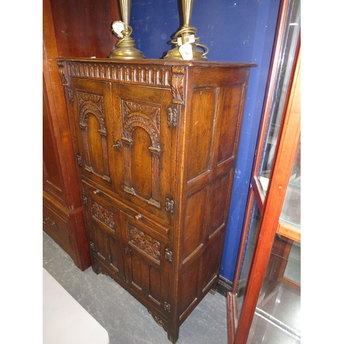 707 - A carved oak priory style drinks cabinet