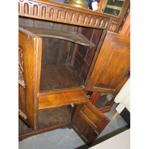 707 - A carved oak priory style drinks cabinet
