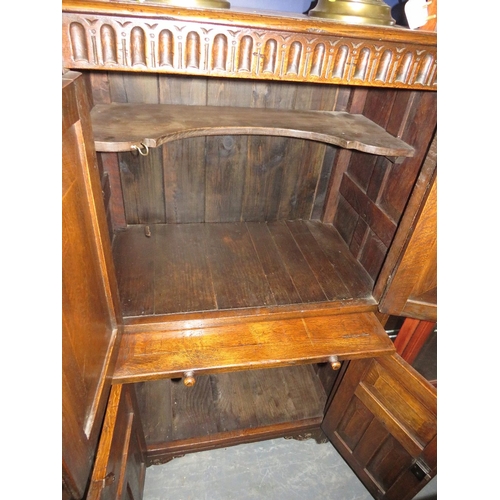 707 - A carved oak priory style drinks cabinet