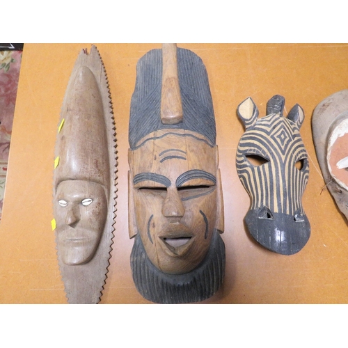 Six various African tribal art masks including one with cowrie shell eyes