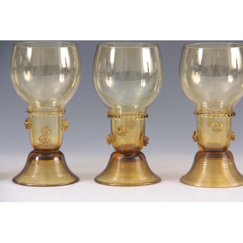 10 - A SET OF 5 CONTINENTAL PALE AMBER WINE GLASSES with rounded bowls and prunted stems on ribbed spread... 