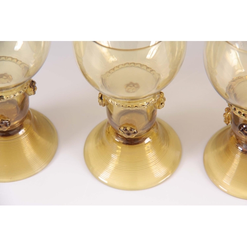 10 - A SET OF 5 CONTINENTAL PALE AMBER WINE GLASSES with rounded bowls and prunted stems on ribbed spread... 