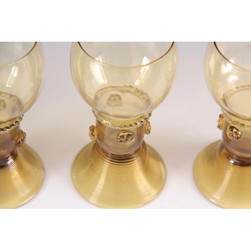 10 - A SET OF 5 CONTINENTAL PALE AMBER WINE GLASSES with rounded bowls and prunted stems on ribbed spread... 