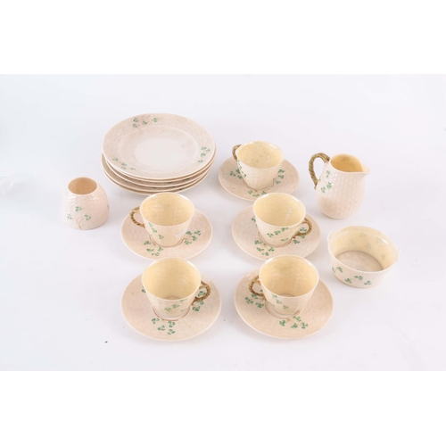 100 - A 20TH CENTURY BELLEEK PORCELAIN PART TEA SET, in a basket weave and shamrock pattern, having milk j... 