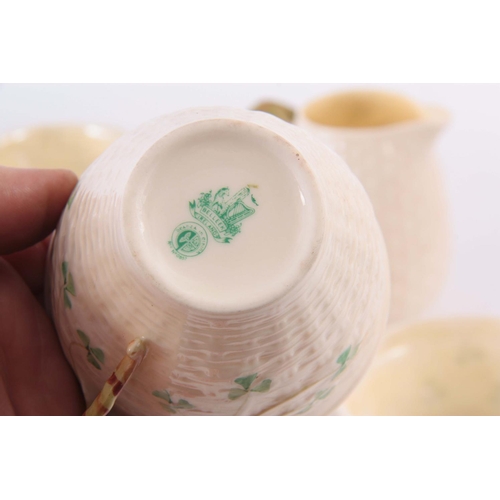 100 - A 20TH CENTURY BELLEEK PORCELAIN PART TEA SET, in a basket weave and shamrock pattern, having milk j... 